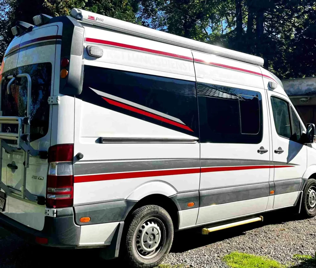 Bílá dodávka s červeno šedým polepem